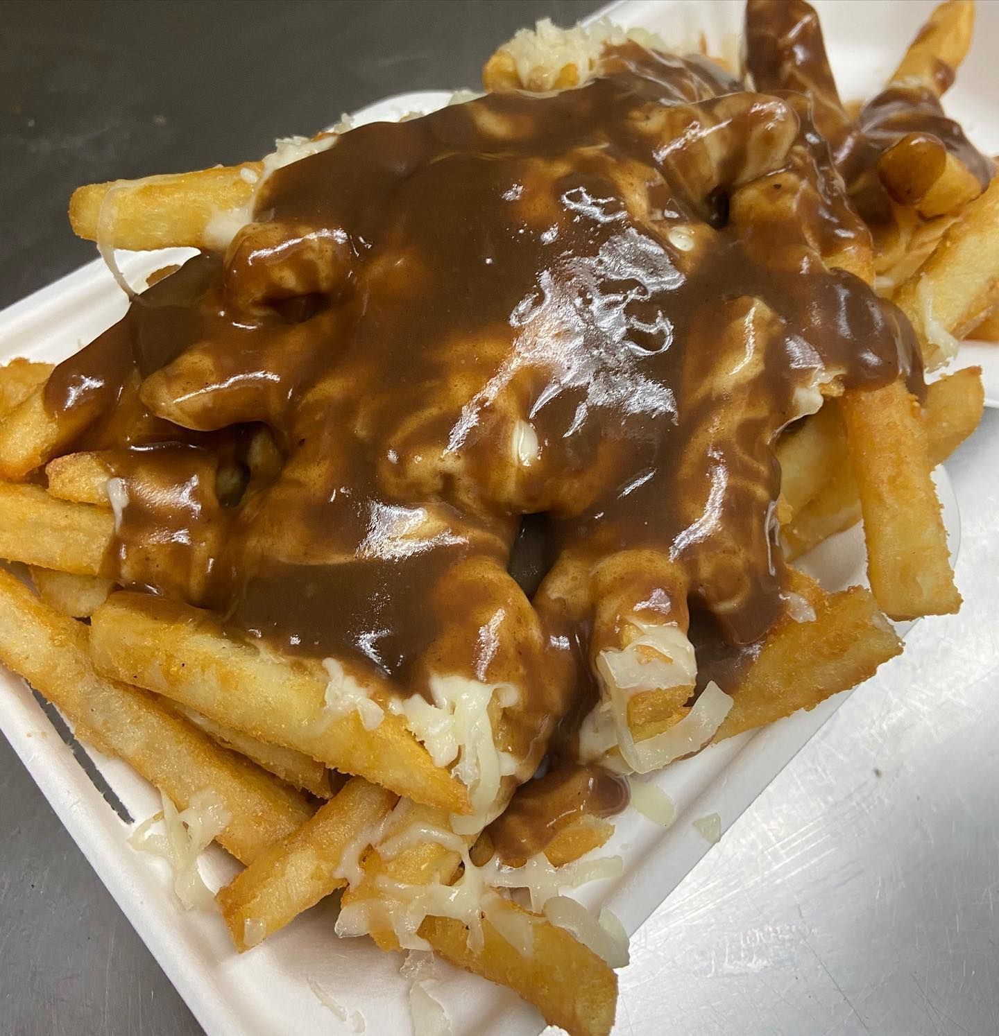 A white plate topped with french fries and gravy