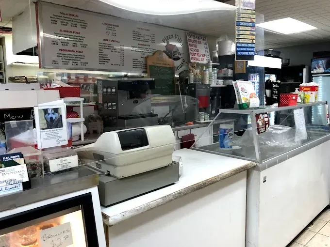 A pizza with chicken , bacon and onions on a wooden cutting board.