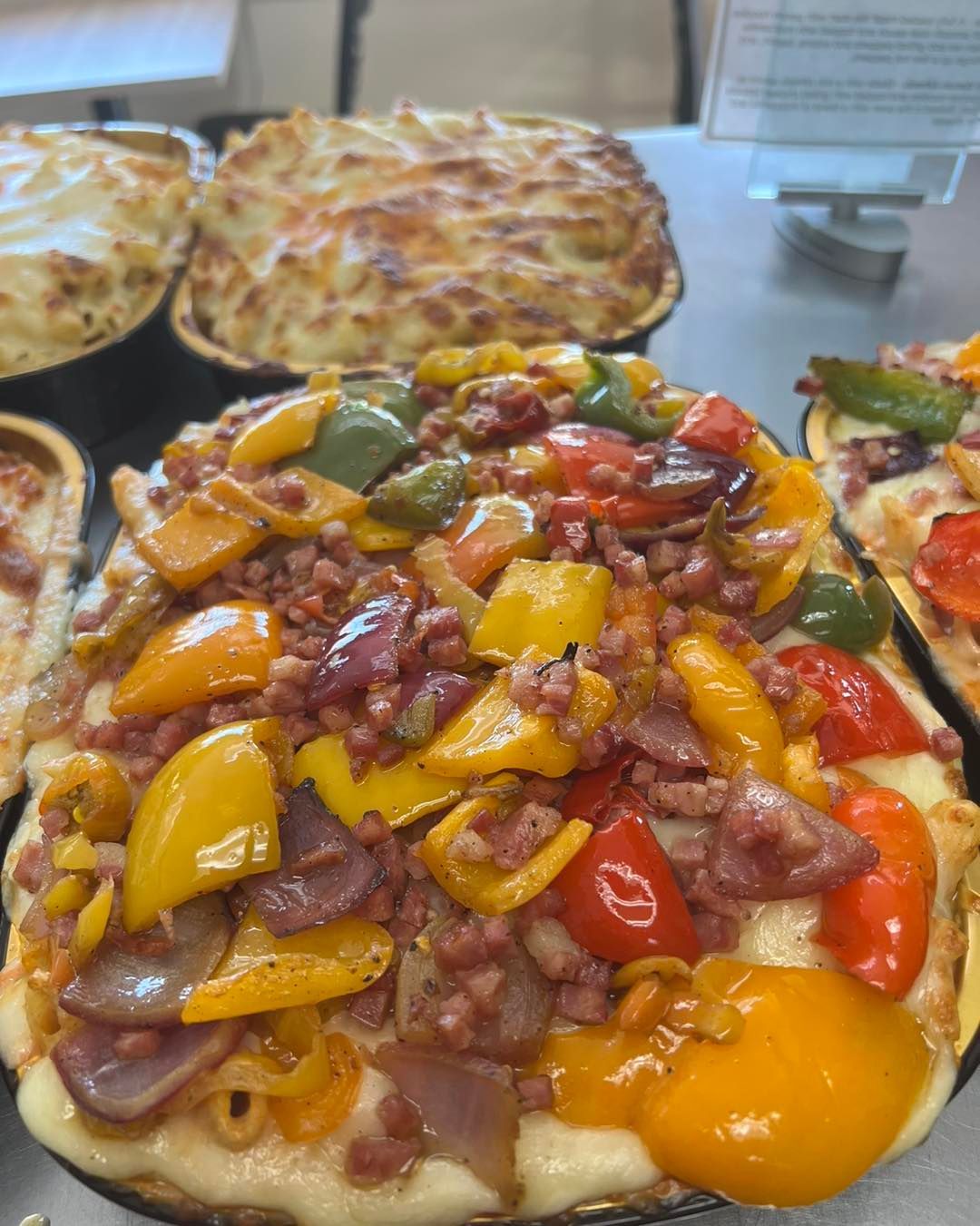 A pizza with a lot of vegetables on it is sitting on a table.