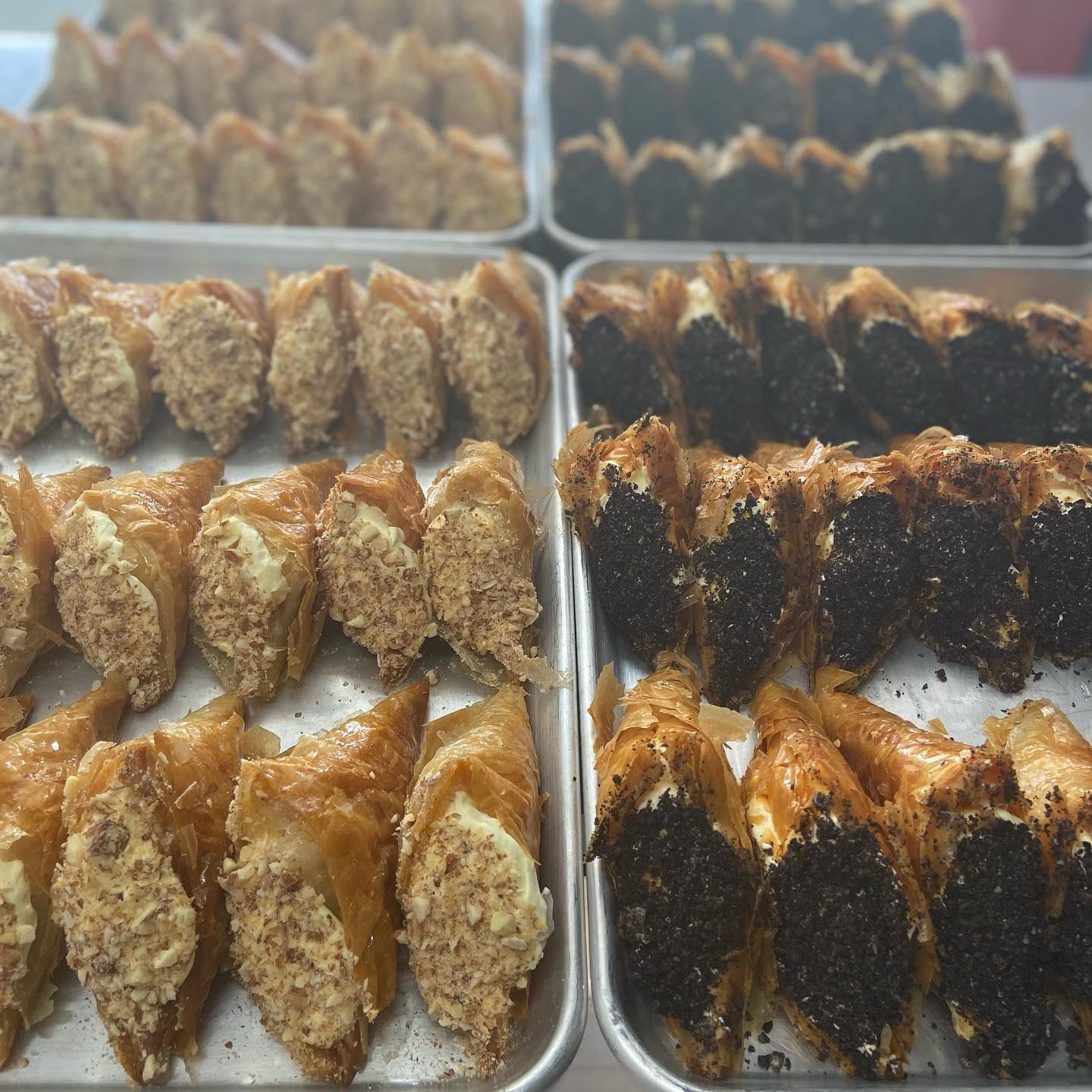 Several trays of food are lined up on a table