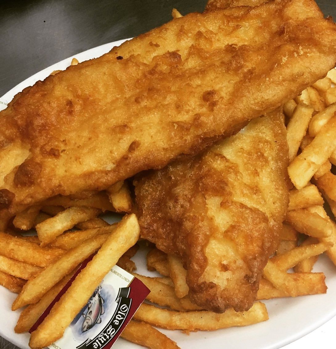A white plate topped with fried fish and french fries