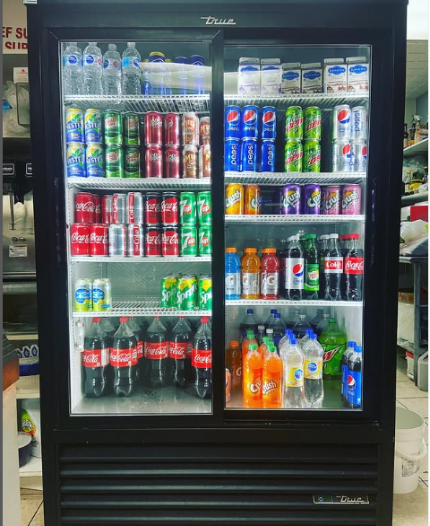 A refrigerator filled with sodas including coca cola and pepsi