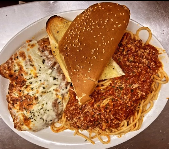 A white plate topped with spaghetti meatballs and bread