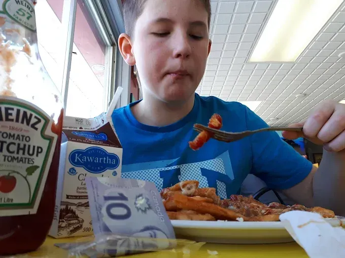A group of people are sitting around a table eating pizza.
