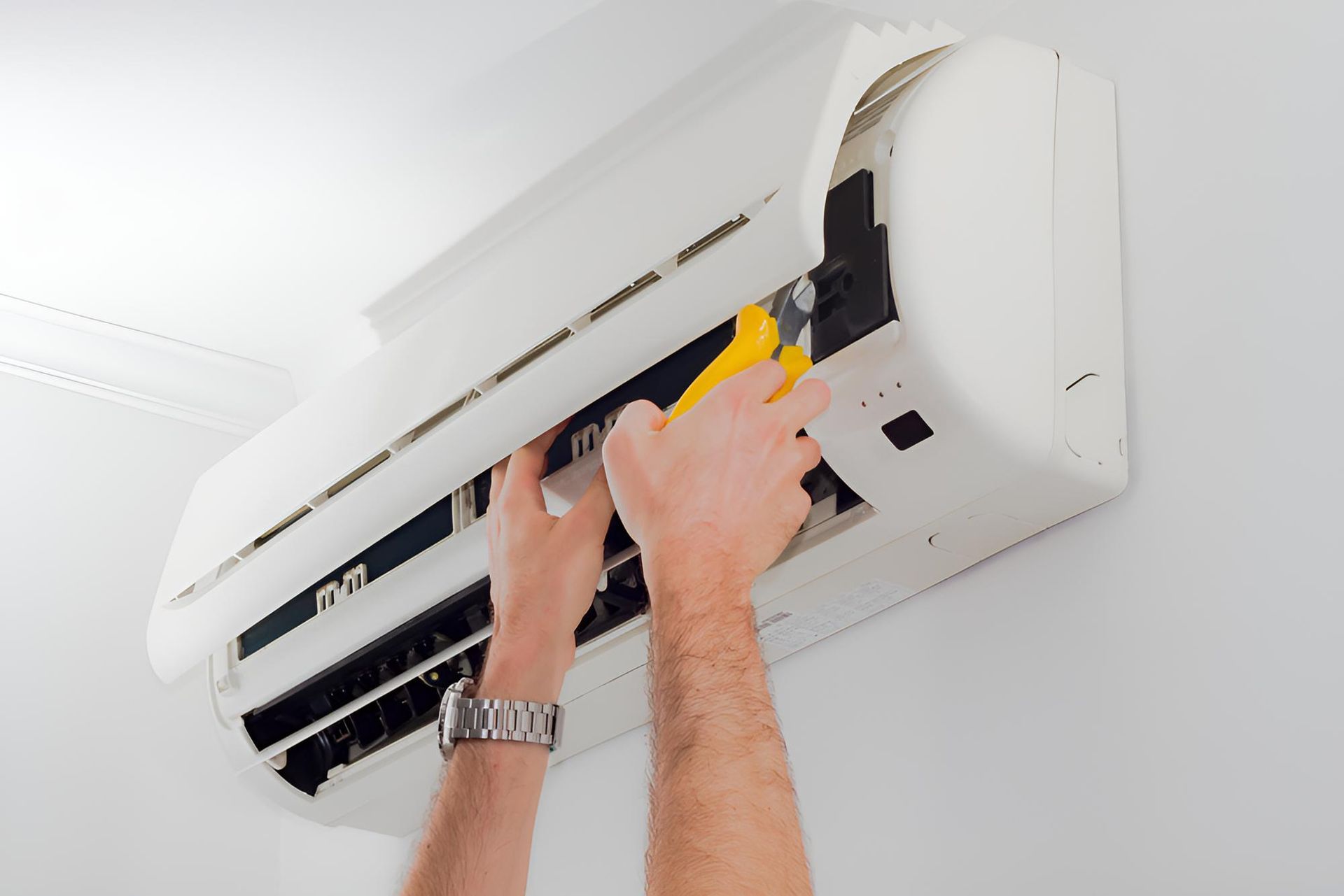 Man is Fixing an Air Conditioner With a Wrench — Tec Electrical & Air In Sandgate, QLD