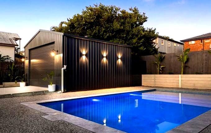 A Black Shed With Lights Shining Down Next To A Pool — Tec Electrical & Air In Rothwell, QLD
