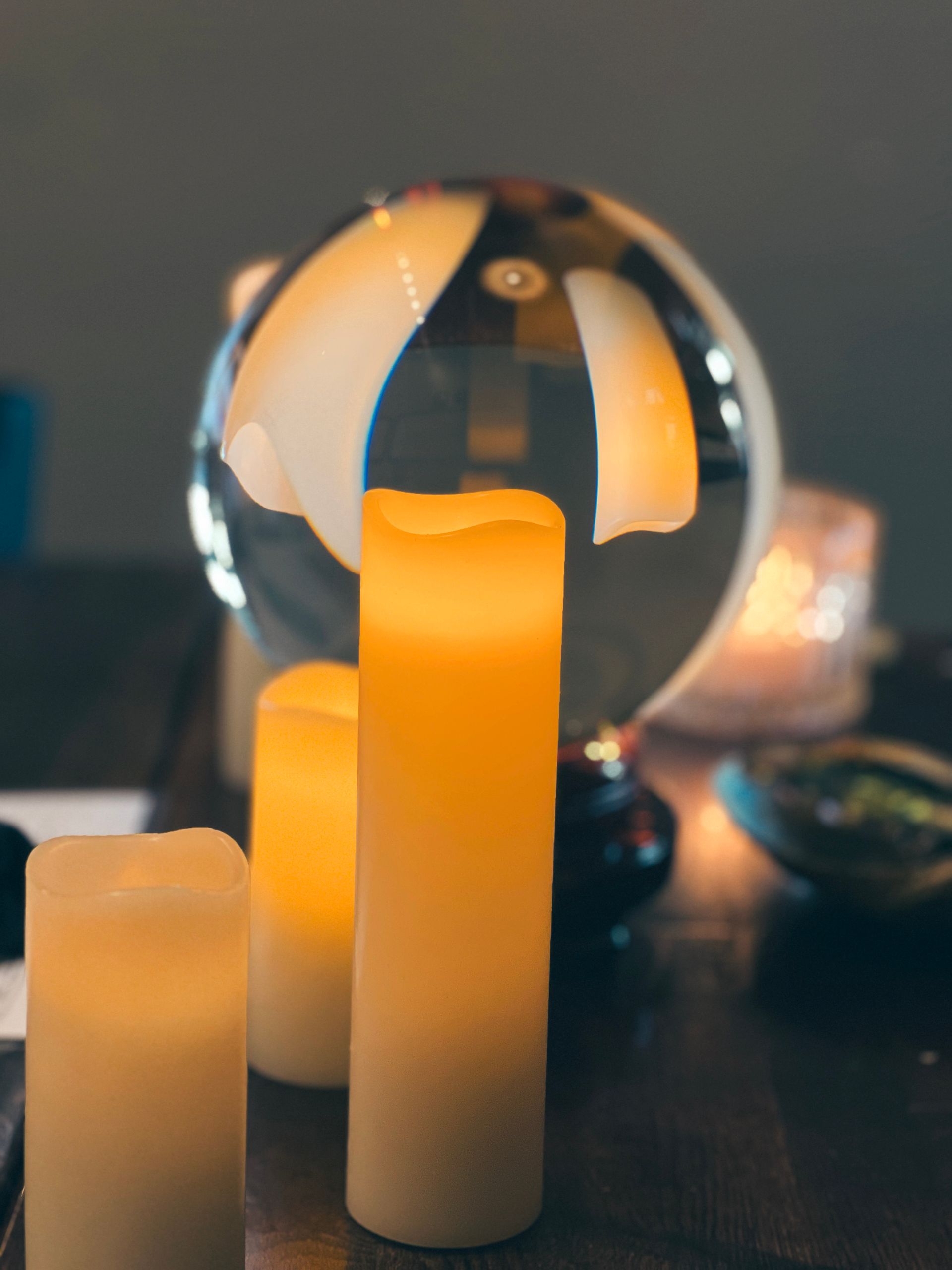 A table with candles and a glass ball on it