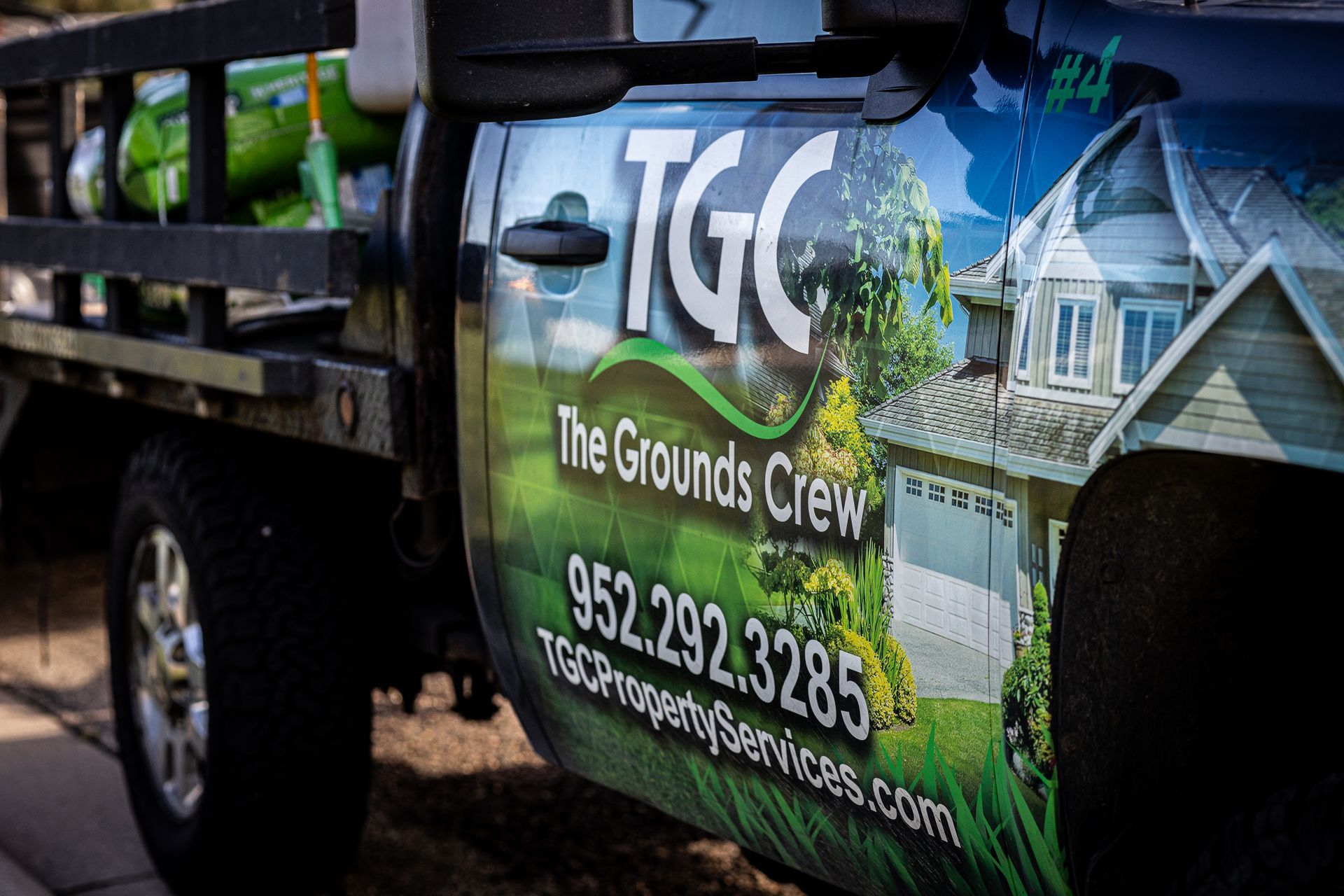 A tgc property services truck is parked in the snow in front of a house.