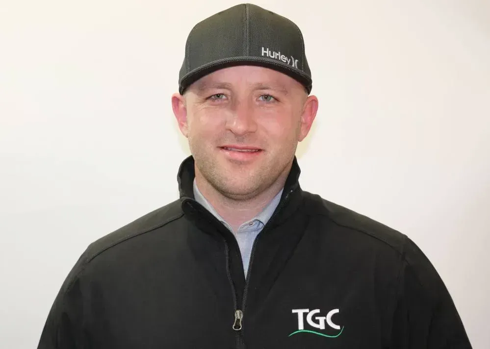 A man wearing a hat and a jacket with the word tgc on it.