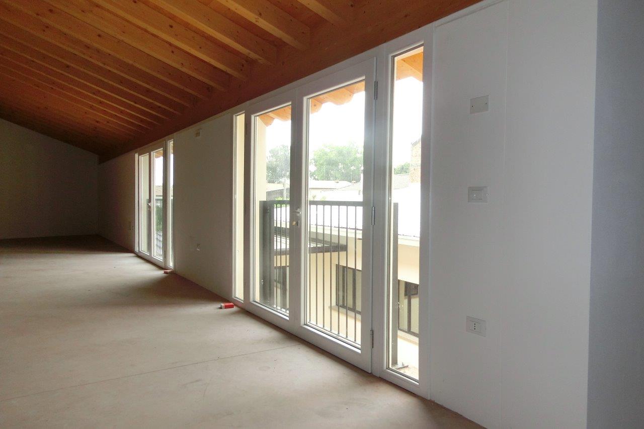 stanza mansardata con finestre bianche