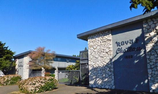 Nova Chateau apartment buildings with stone facades under a clear blue sky.