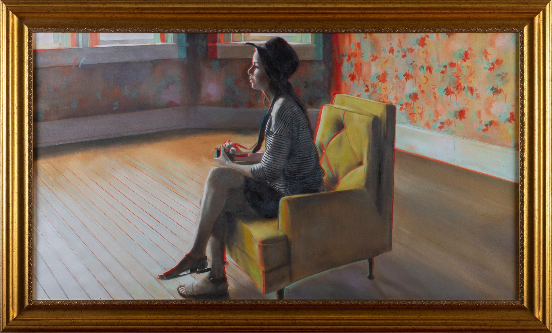 Mujer sentada en una silla amarilla, con cámara en mano, mirando por la ventana. La luz se filtra en el suelo. Papel tapiz floral.