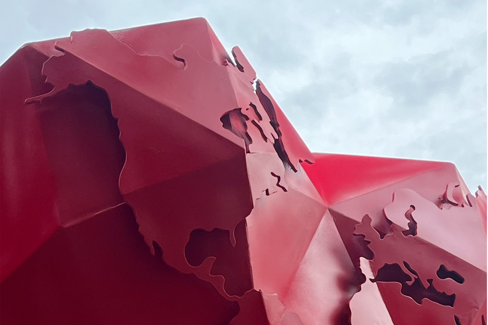 Escultura geométrica roja, con forma de continentes.