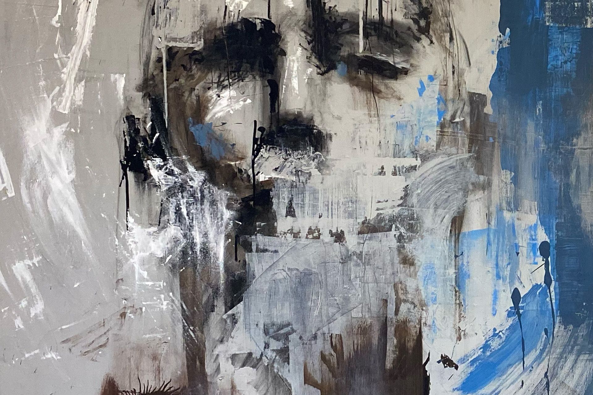 Pintura de retrato abstracto en tonos grises, negros, azules y blancos; un rostro con ojos cerrados y gotas de pintura.