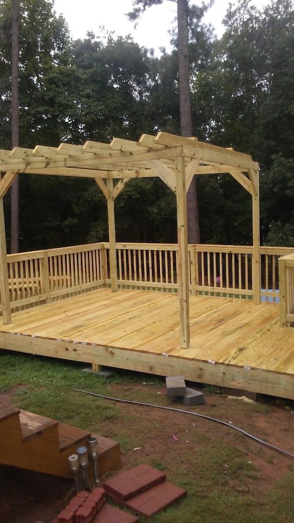 A wooden deck with a pergola on top of it