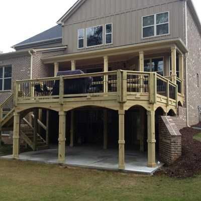 A large house with a large wooden deck in front of it