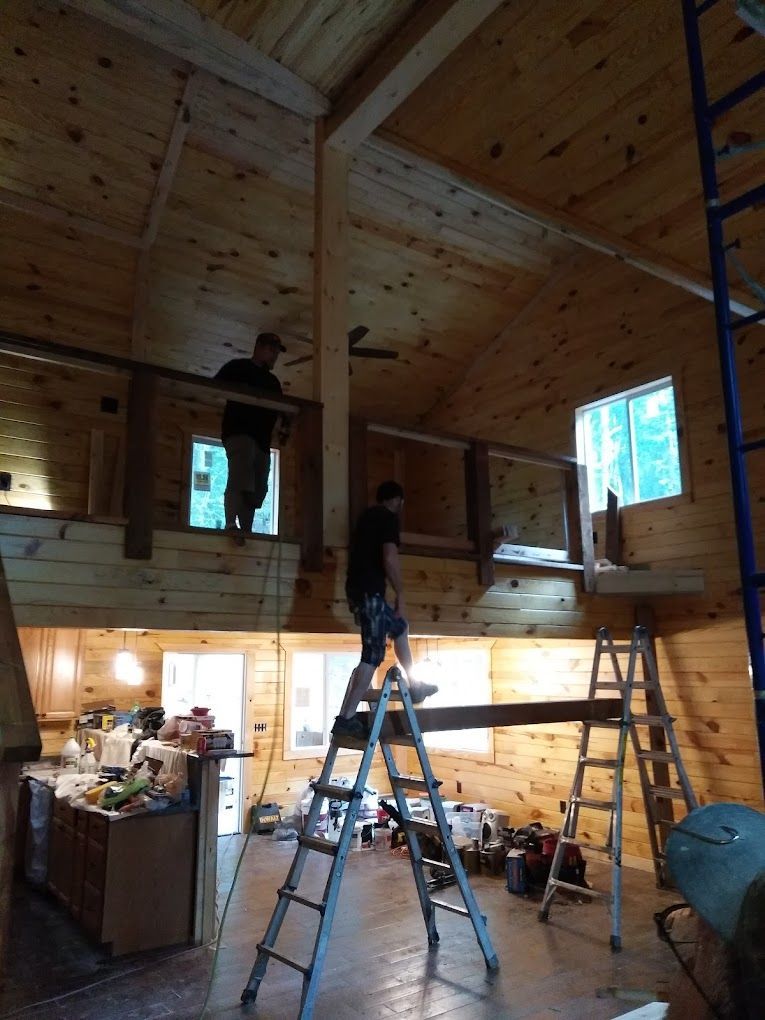A man standing on a ladder in a wooden house