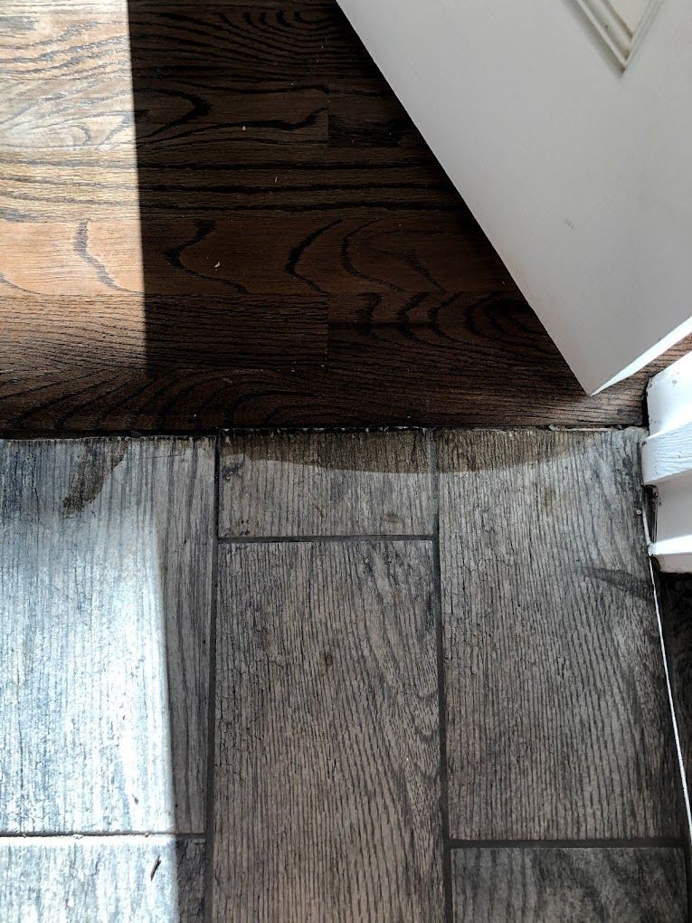 A close up of a wooden floor next to a door