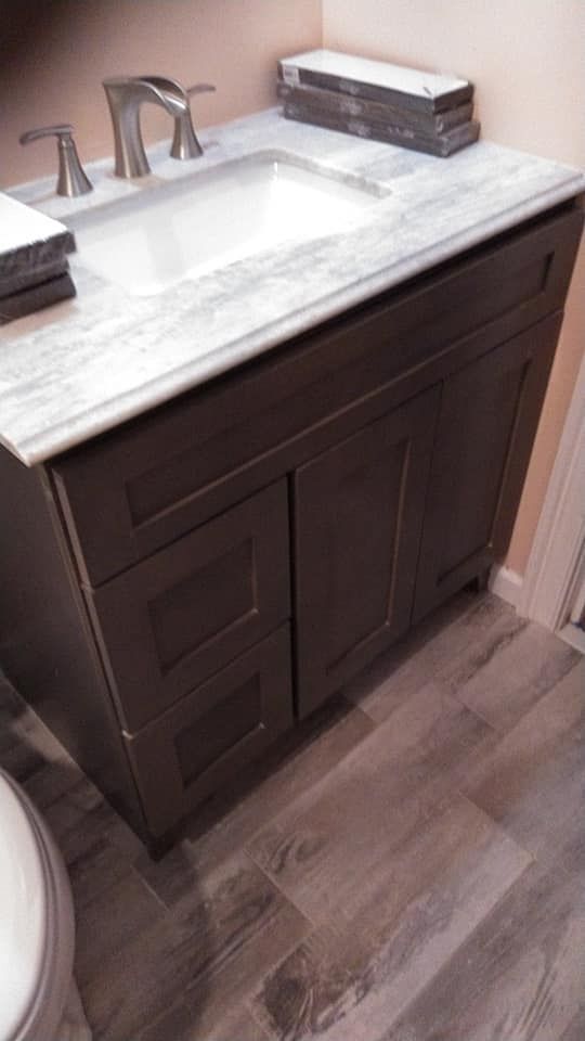 A bathroom vanity with a sink and a toilet