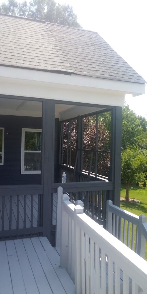 A house with a screened in porch and a white railing