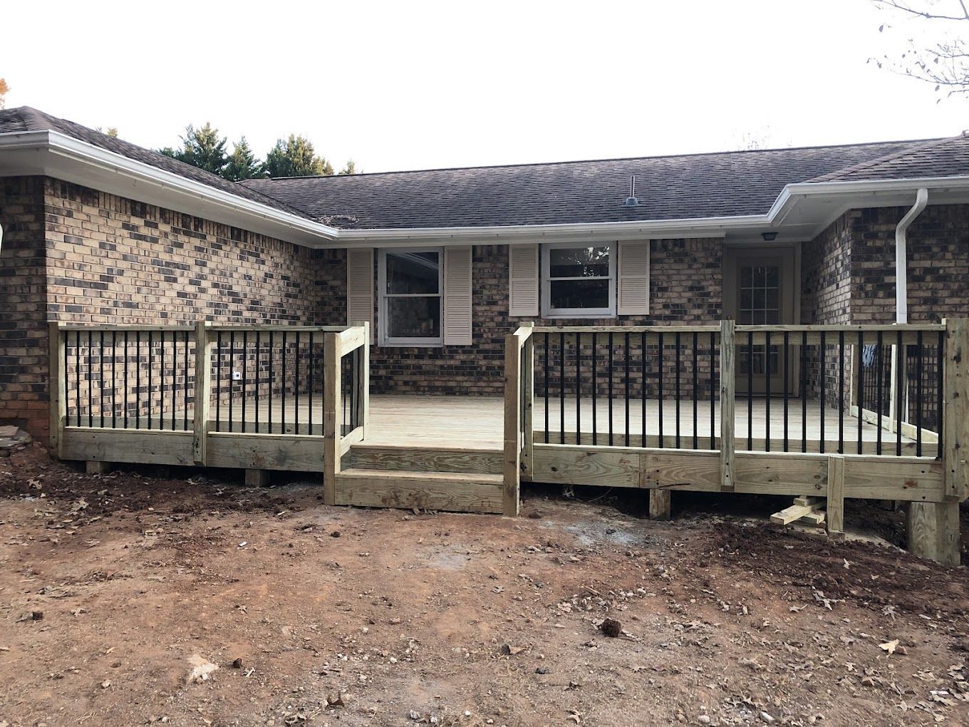 A brick house with a wooden deck in front of it