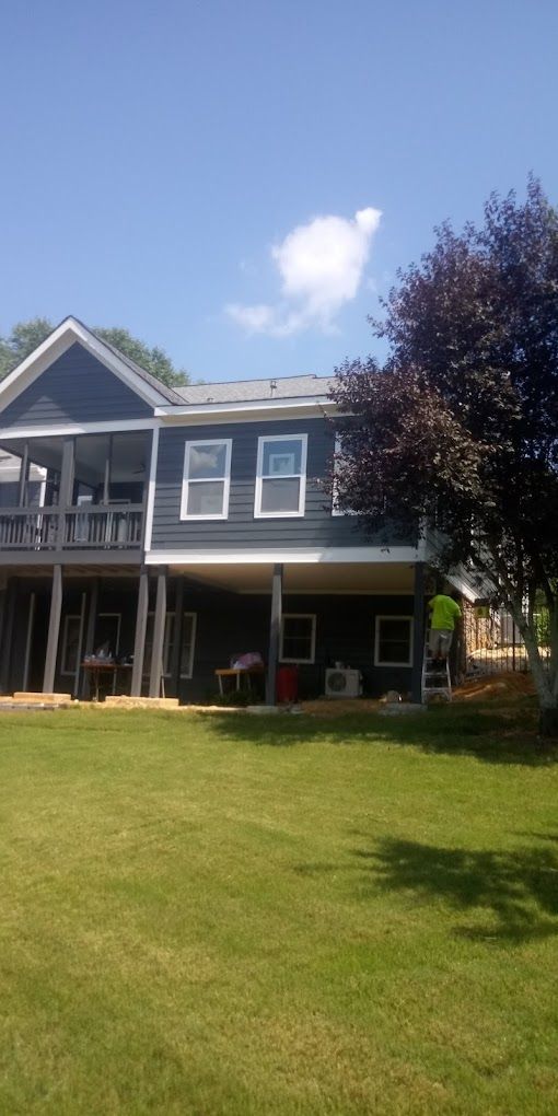 A large house with a large lawn in front of it on a sunny day