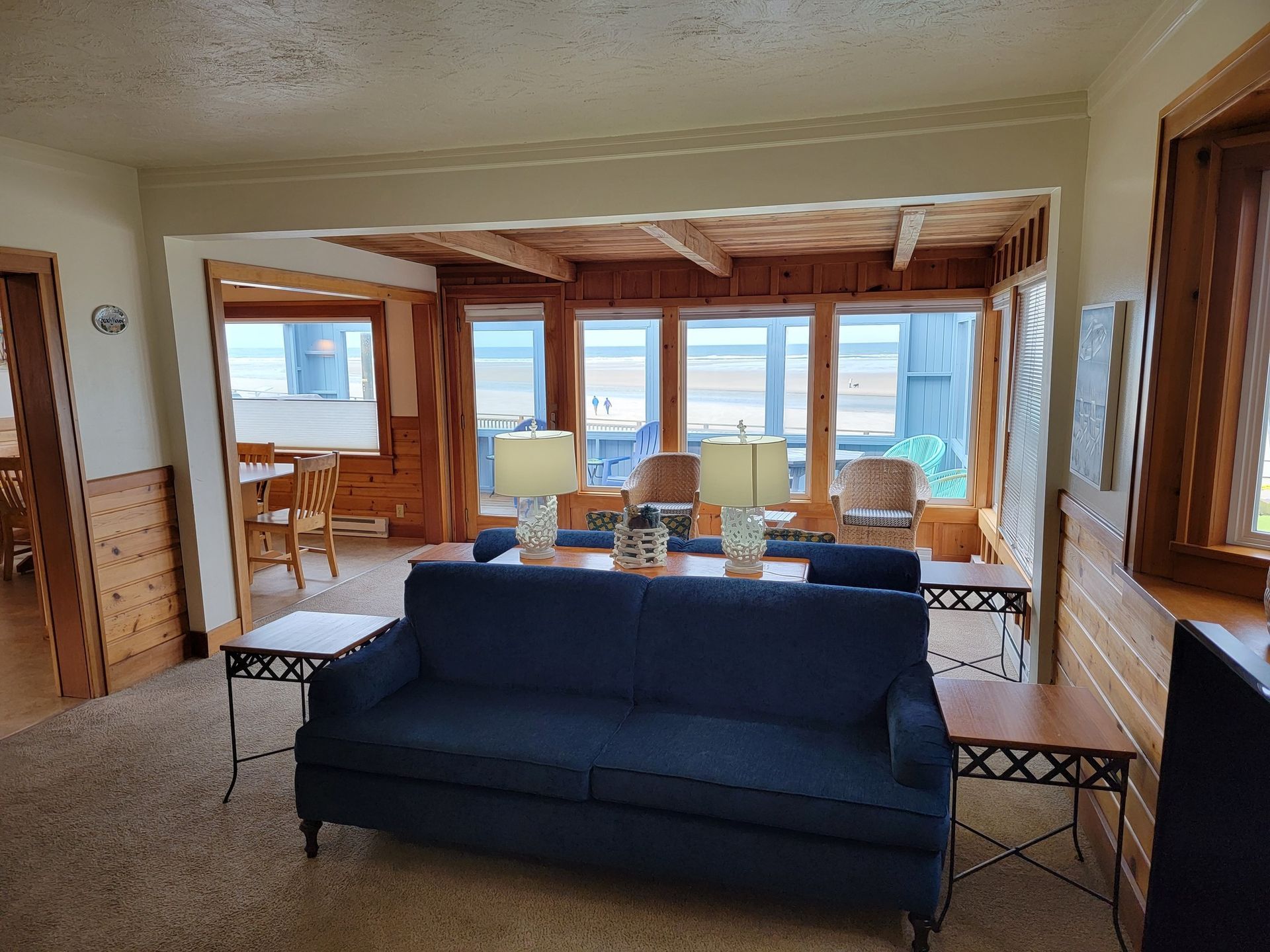 A living room with a blue couch and a lot of windows