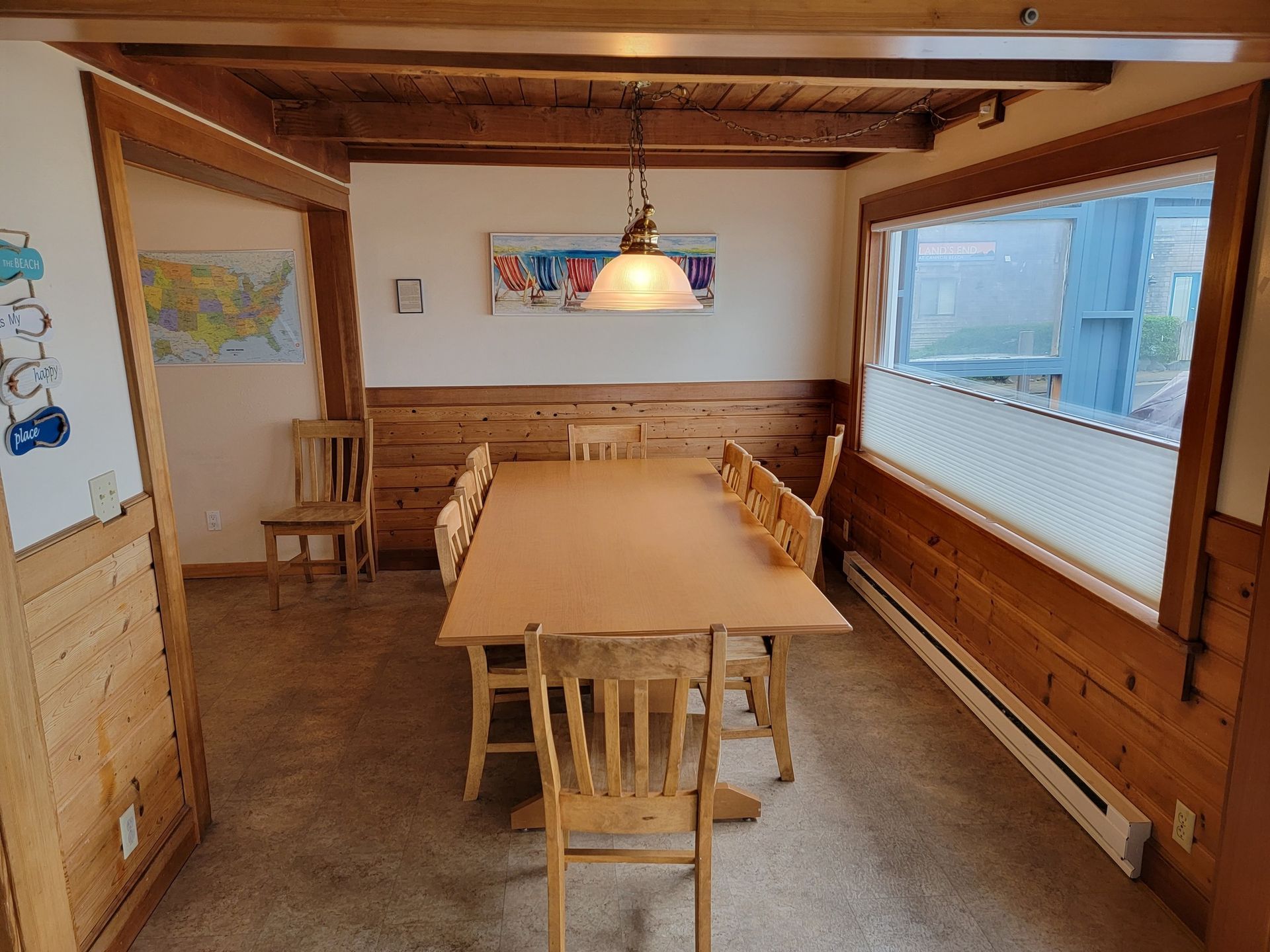 A dining room with a long wooden table and chairs.