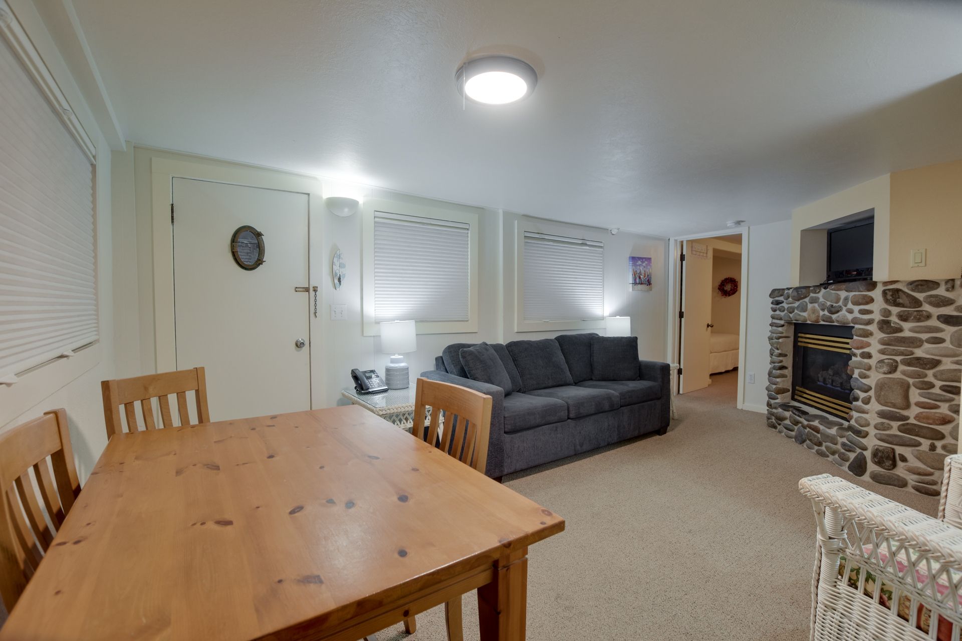 A living room with a couch , table and chairs and a fireplace.