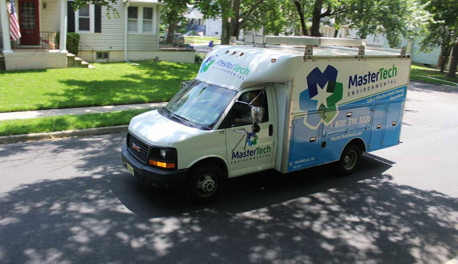 Mastertech Environmental work van parked outside a residential home