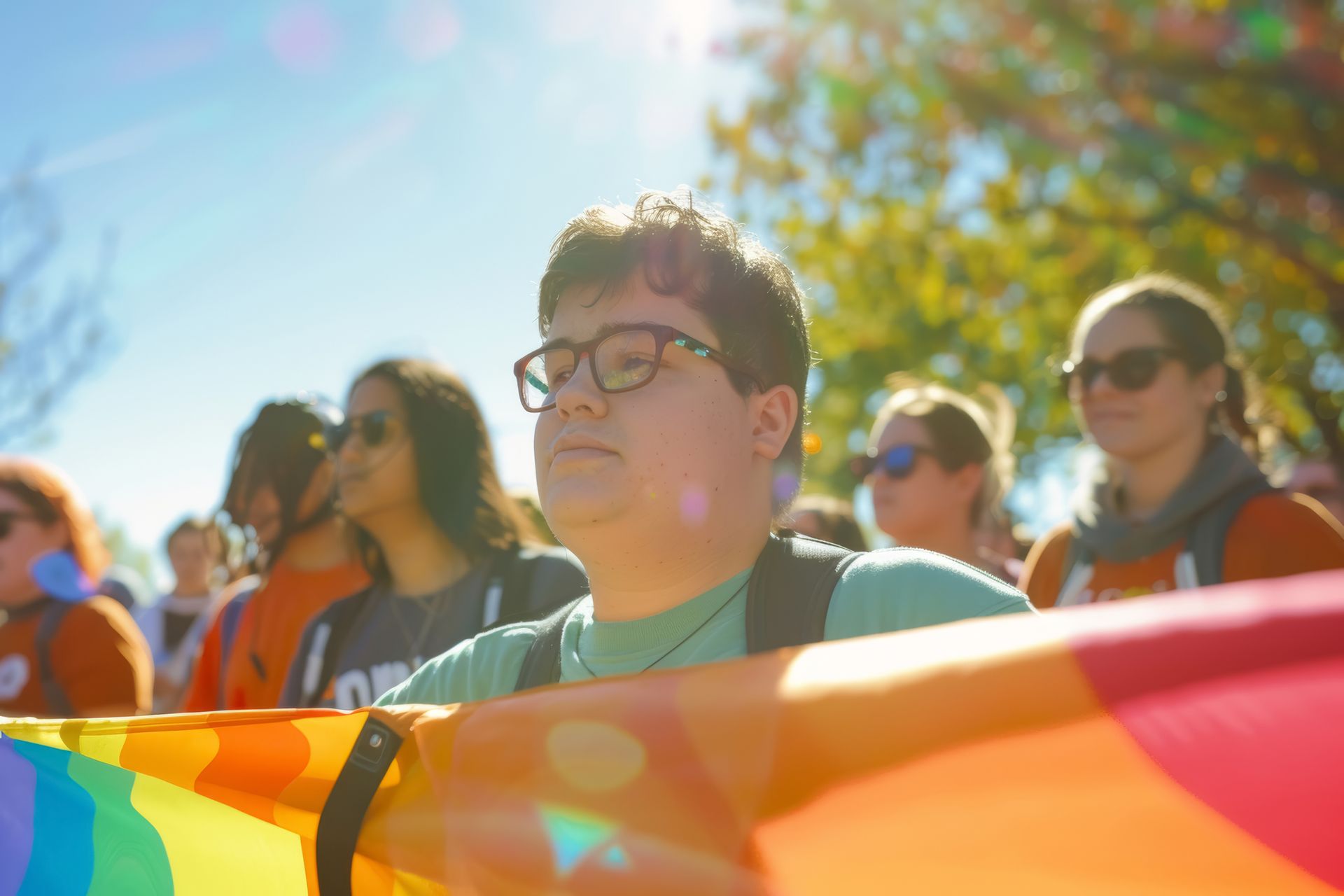 A group of people are holding a rainbow flag at a protest.