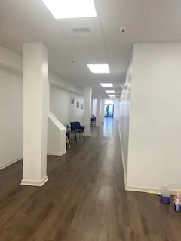 A long hallway with wooden floors and white walls
