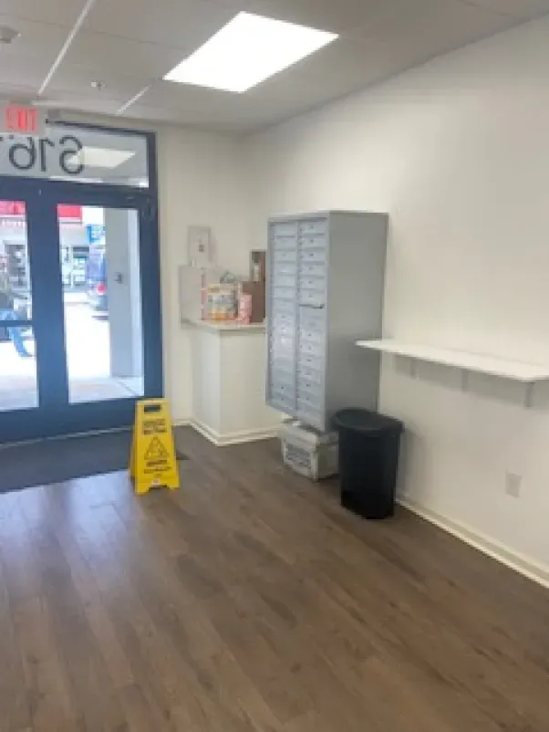 An empty room with a yellow caution sign on the floor