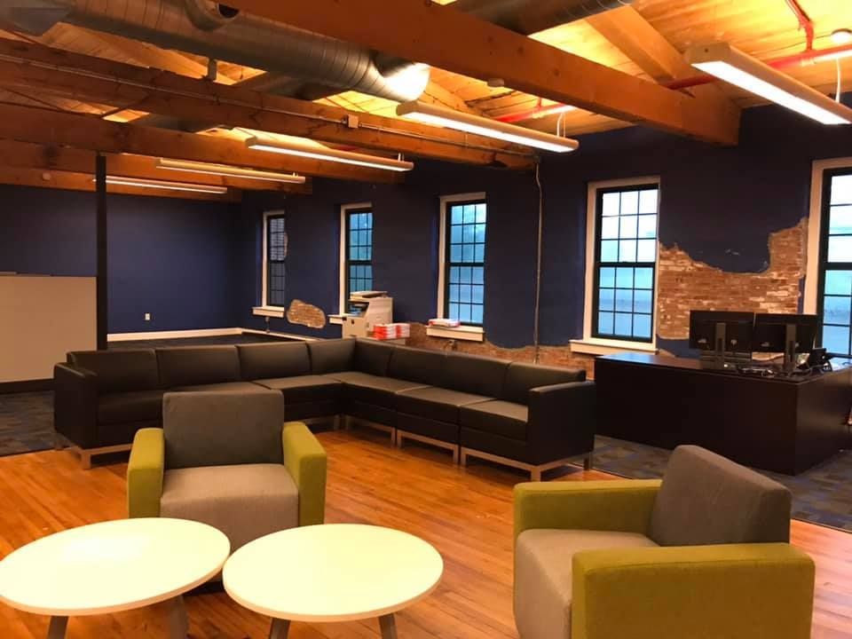 A living room with a couch , chairs , tables and a desk.