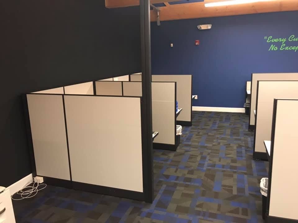 A cubicle in an office with a quote on the wall