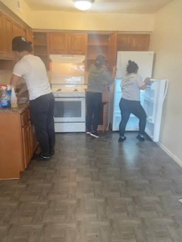 A group of people are cleaning a kitchen together.