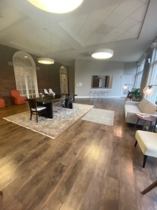 A living room with hardwood floors , a table and chairs.