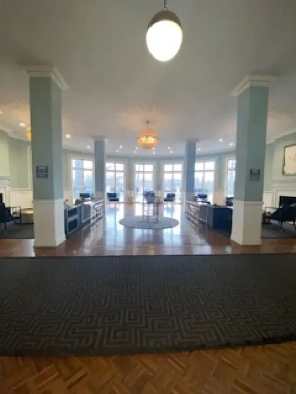 A large room with a lot of windows and a rug on the floor.