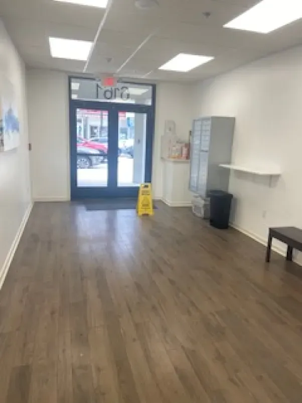 An empty room with a yellow caution sign on the floor