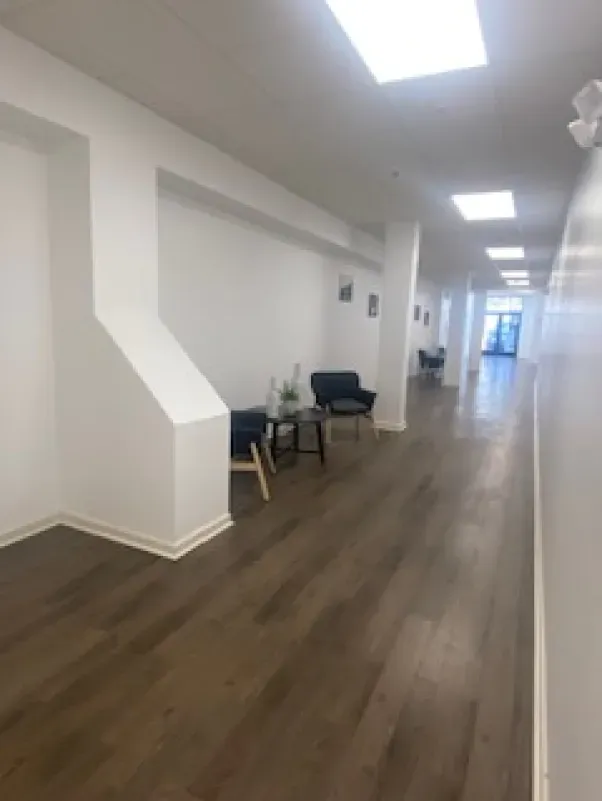 A long hallway with wooden floors and white walls