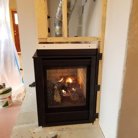 A fireplace is being built into a wall in a room.