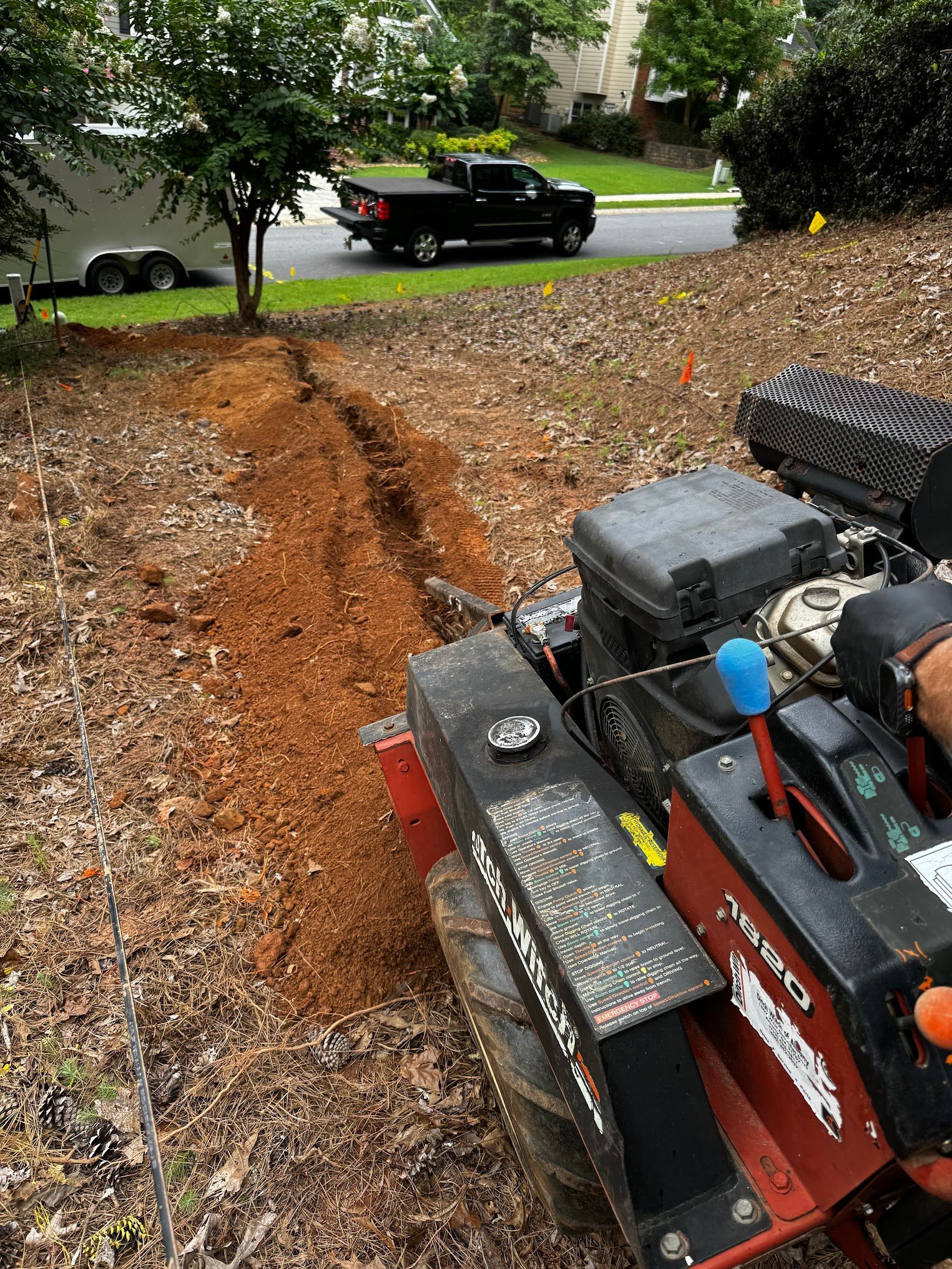 A person is using a tractor to dig a hole in the ground.