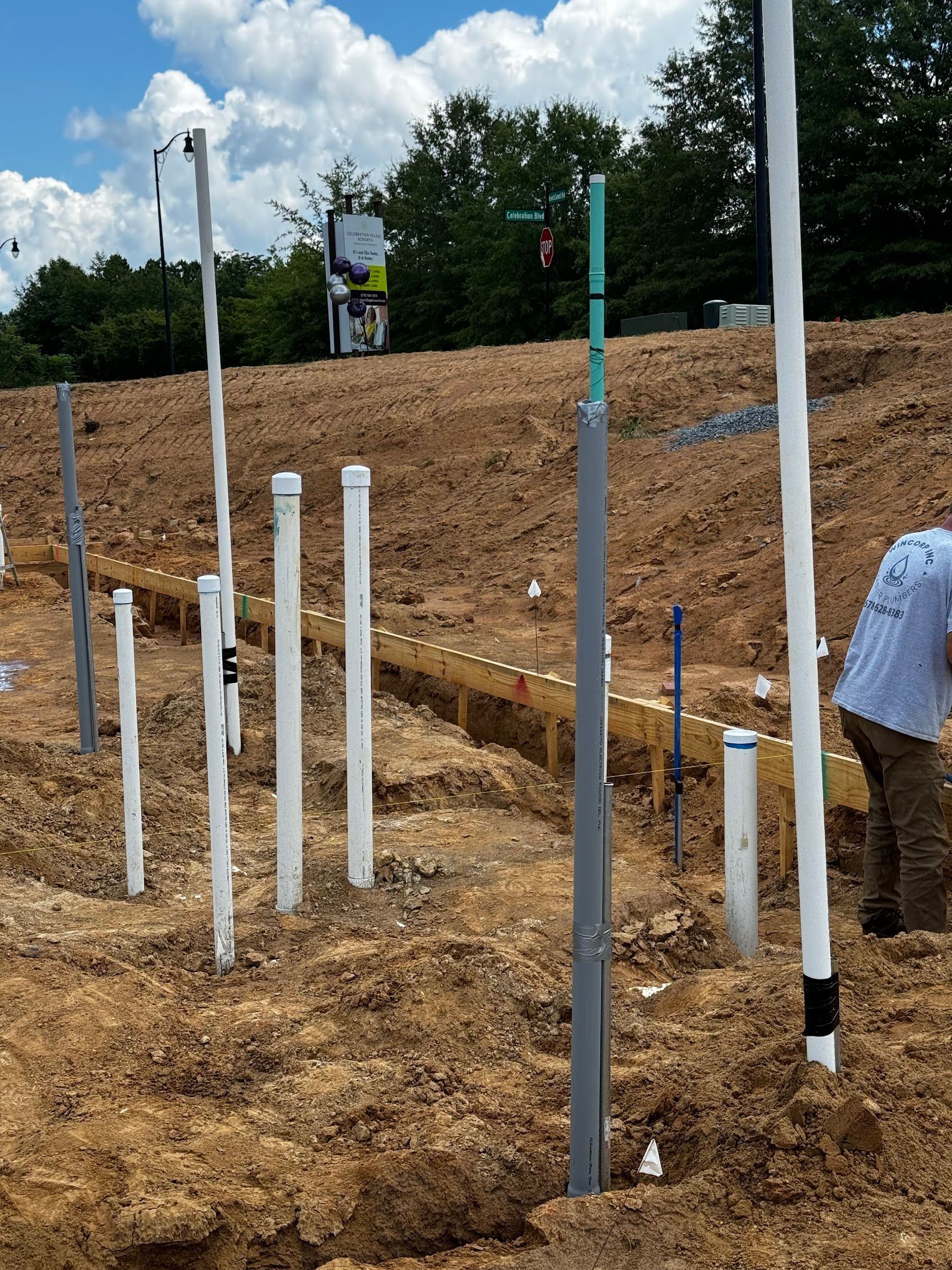 A construction site with a lot of pipes in the dirt