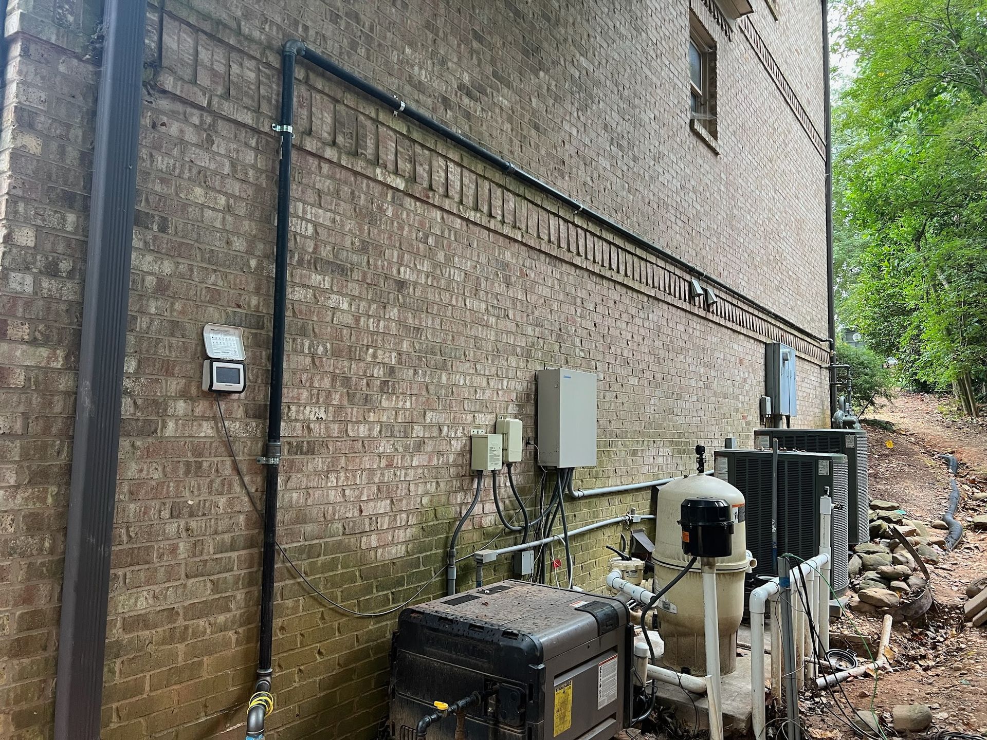 A brick building with a lot of pipes on the side of it.