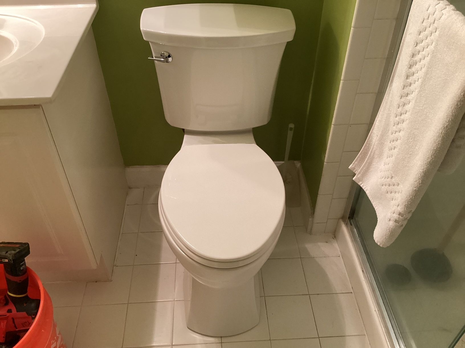 A white toilet is sitting in a bathroom next to a sink.