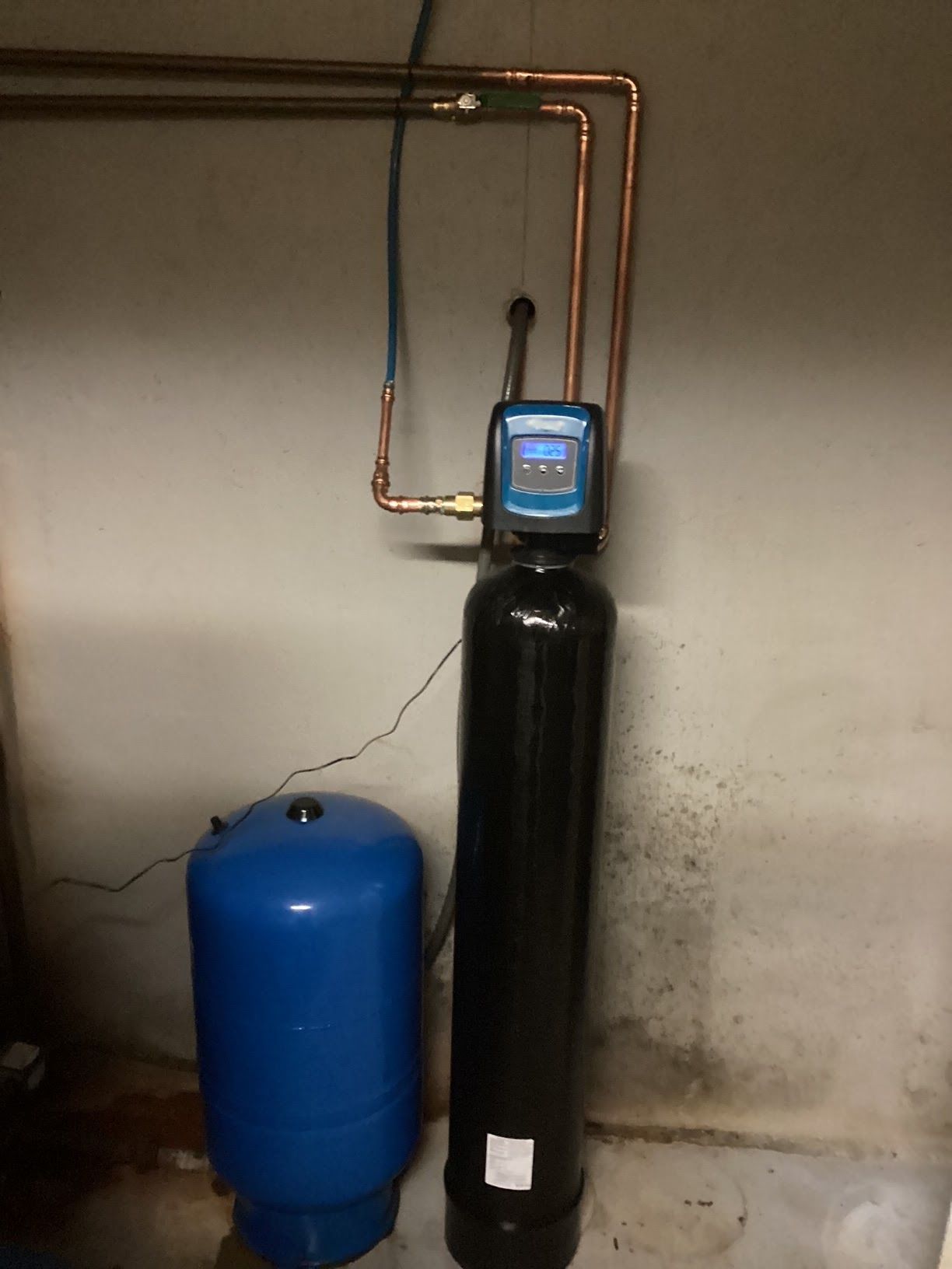 A black water filter is next to a blue tank