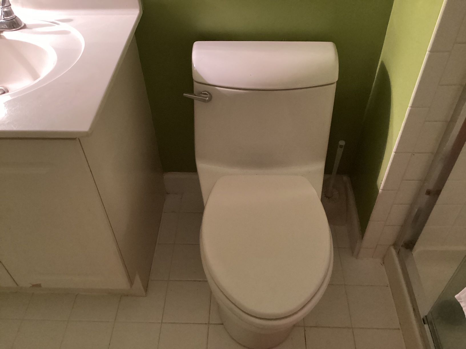 A white toilet in a bathroom next to a sink