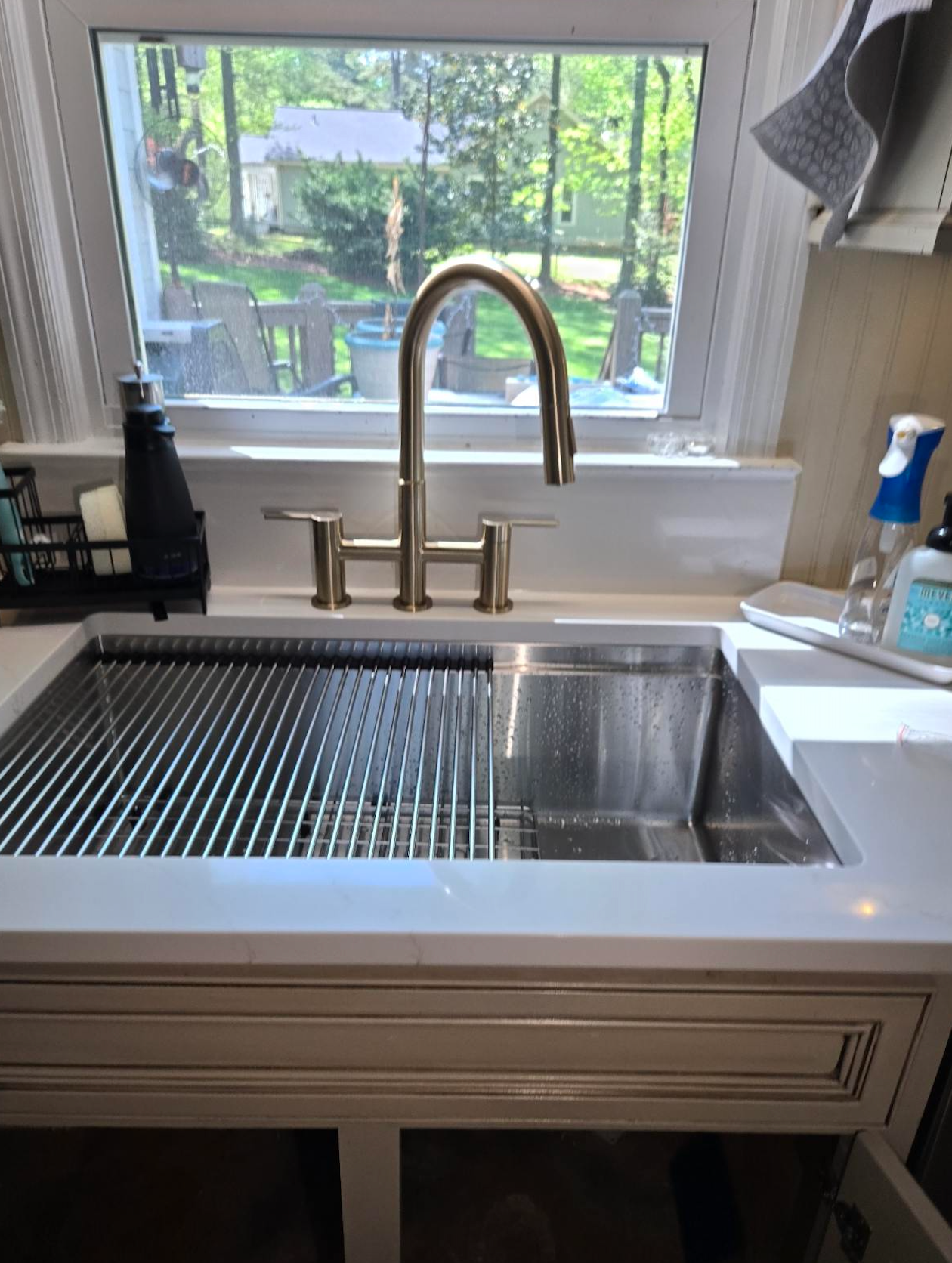A kitchen sink with a faucet and a window.
