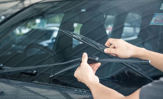 external view of the windshield with hands holding wipers