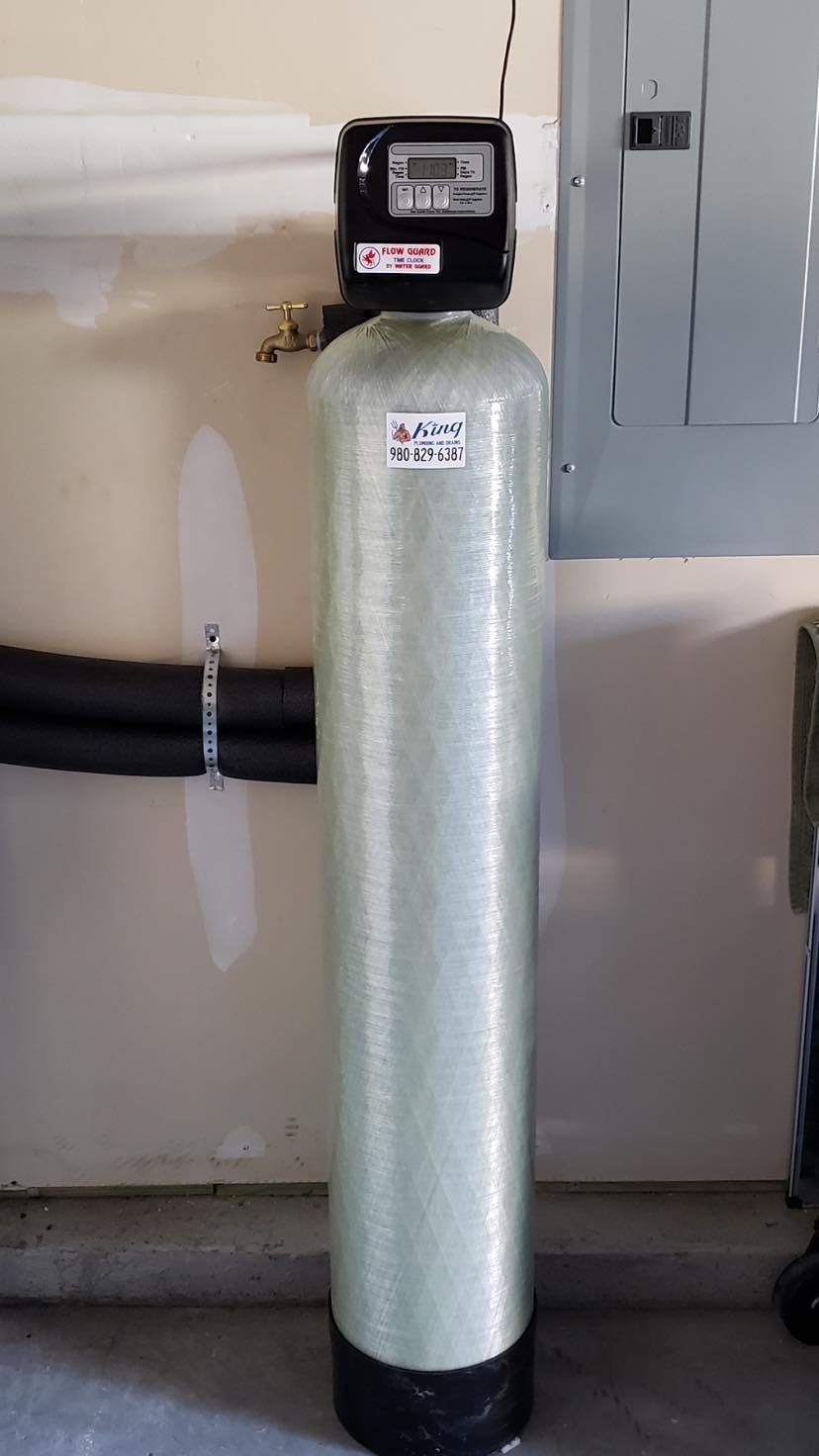 A water filter is sitting in a garage next to a wall.
